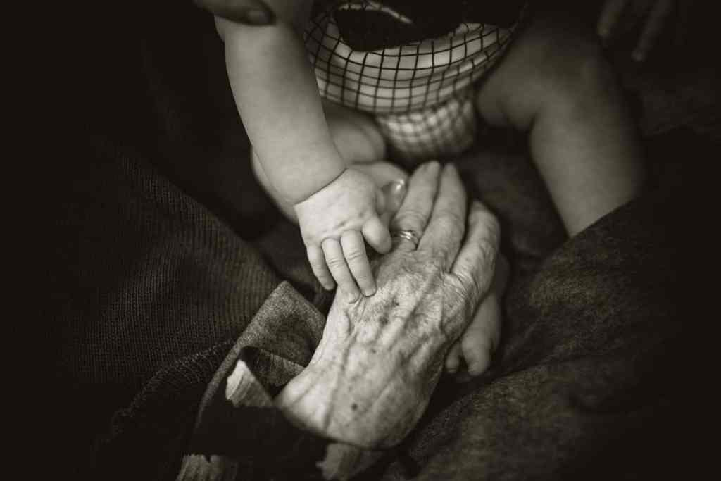 baby and elderly hand in hand
