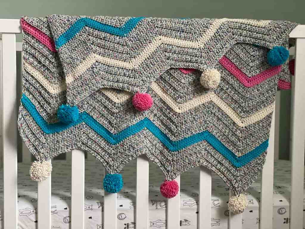 Crochet blanket hanging over crib