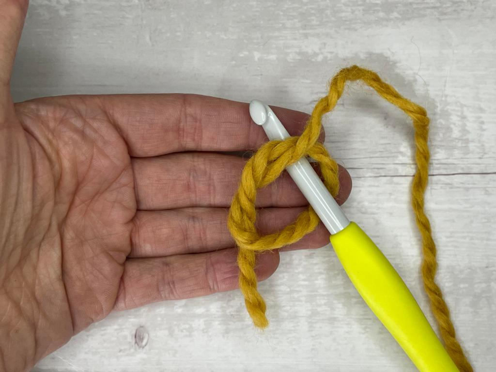 step by step photos illustrating how to make a magic circle crochet stitch