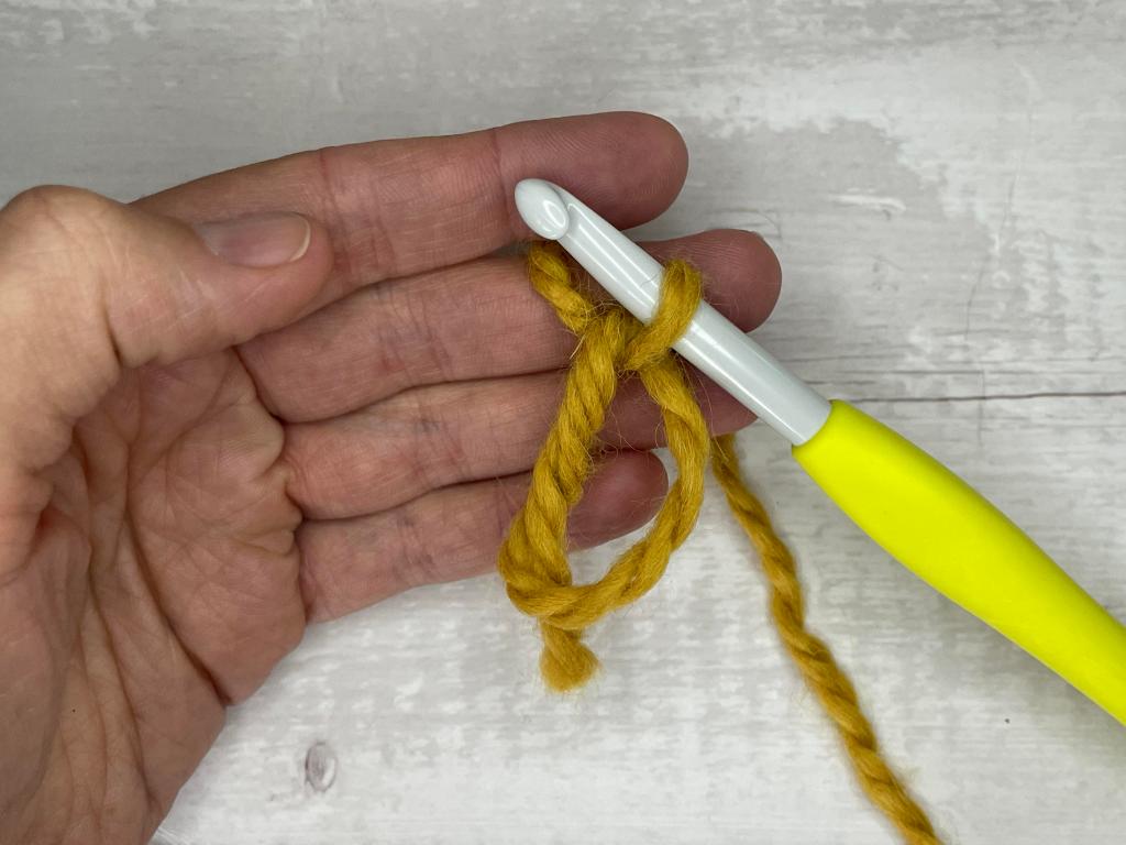 step by step photos illustrating how to make a magic circle crochet stitch