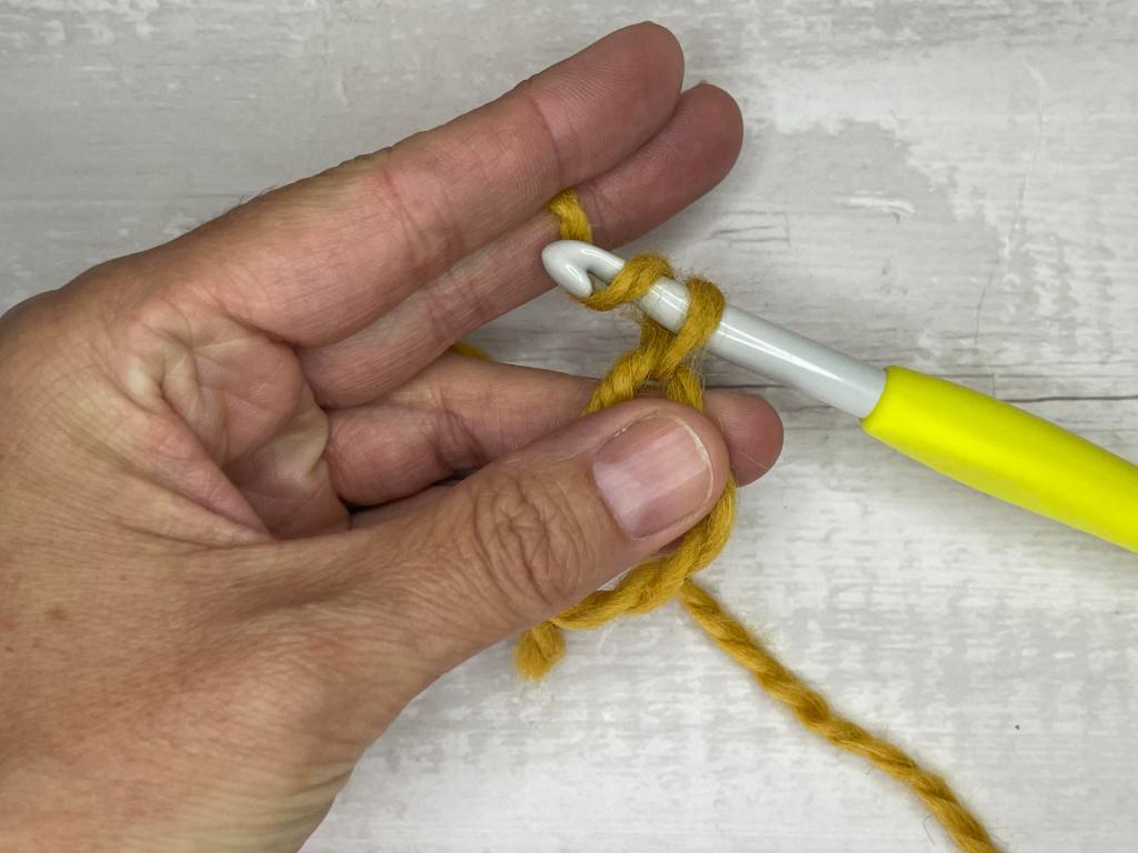 step by step photos illustrating how to make a magic circle crochet stitch